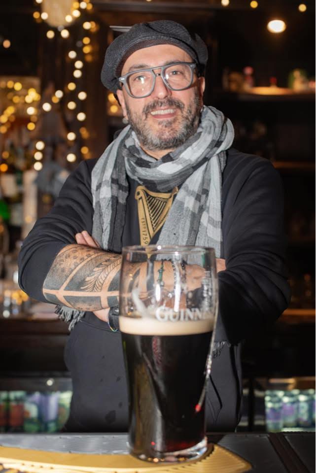 Nicola, fondatore del Temple Bar, dietro il bancone con una pinta di Guinness